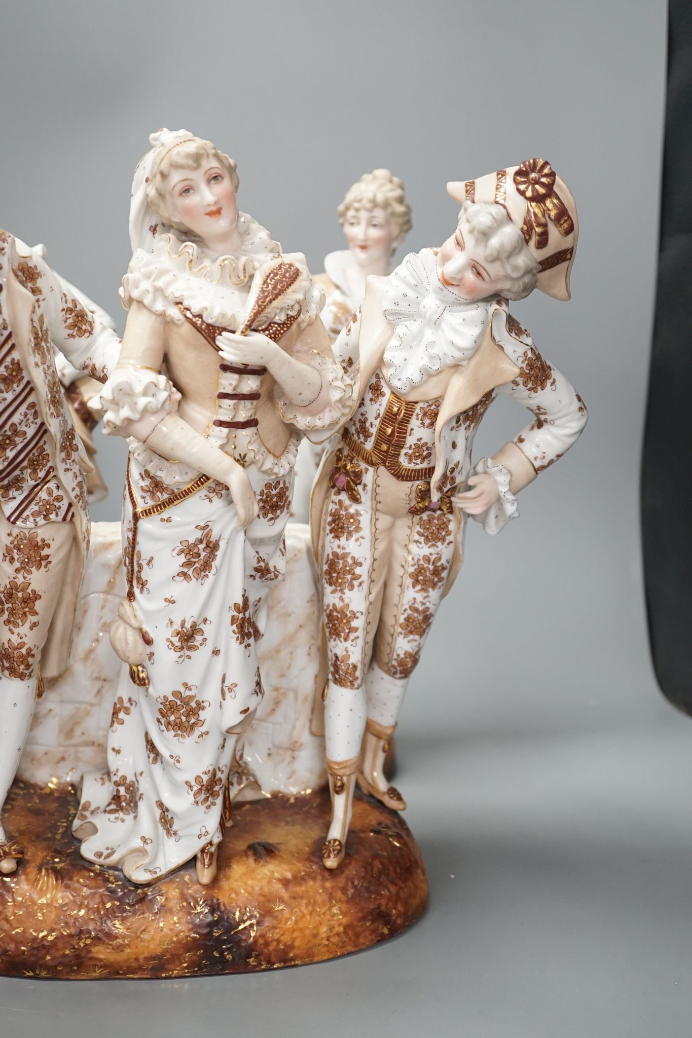 A pair of large French porcelain figures, 38cm, and a figural group en suite